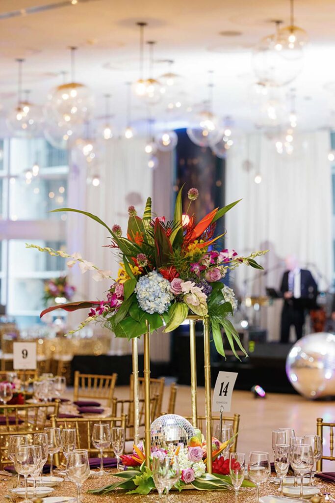 Willard planned a wedding in October with a “Mamma Mia” disco vibe, with details including disco ball lights illuminating the tropical floral arrangements. Photo by The Cardonas