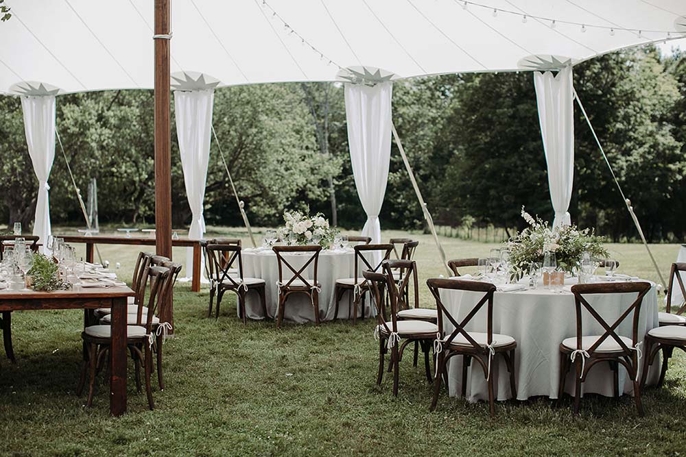 EVL Events often uses sailcloth tents, paired with farm tables and draping. Photo by Sarah Bridgeman Photography