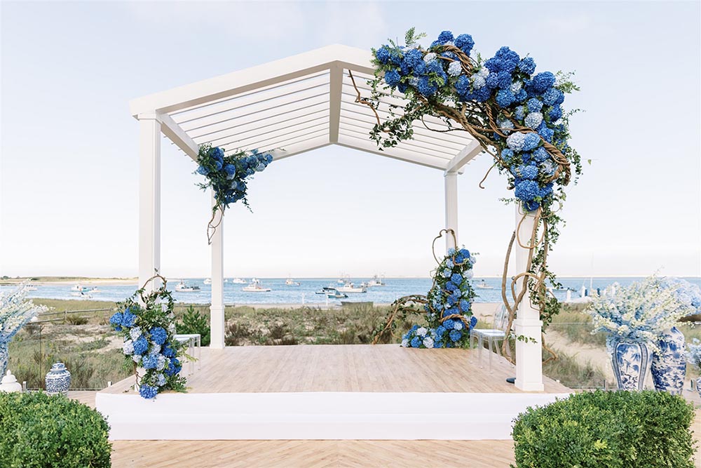 At a Cape Cod wedding, HMR Designs framed the coastal waters with a simple gazebo adorned with hydrangea. Photo by Allan Zepeda Photography