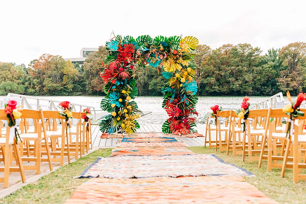 Altar Ego Weddings created this bright, tropical wedding ceremony backdrop. Photo by Keira Hand Photography