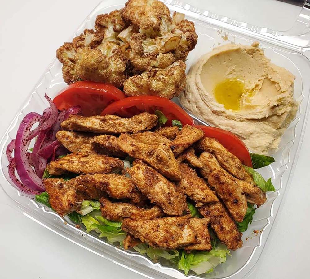 The Mix It Up combo from Dory's Mediterranean Grill comes with one protein and two vegan options; pictured are chicken shawarma, fresh fried cauliflower and hummus.